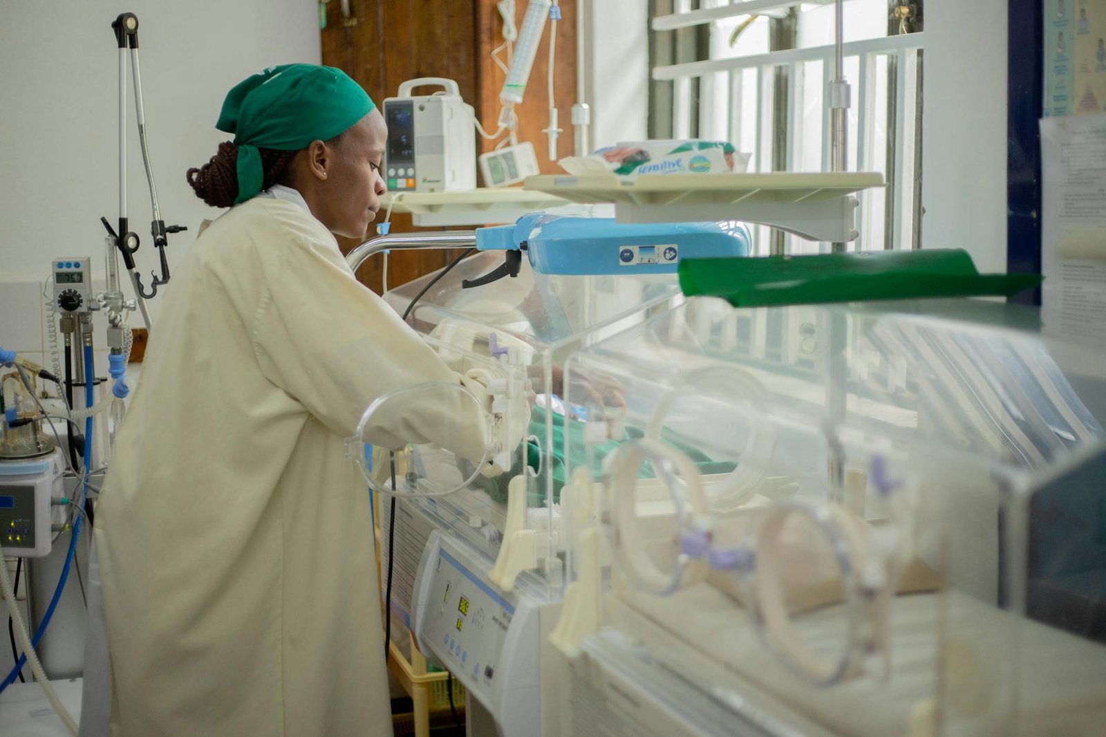 Doctor attending to a newborn in incubator